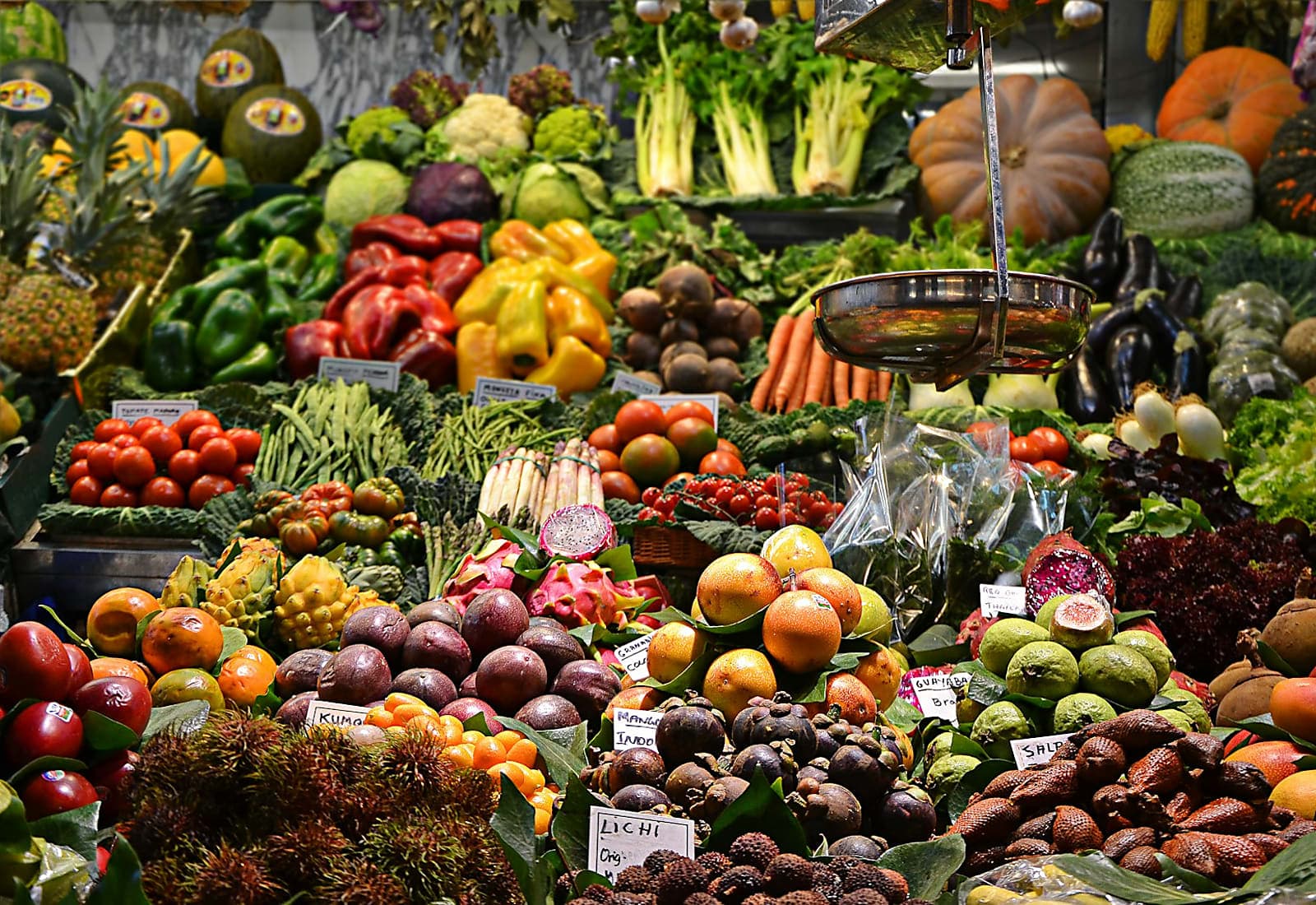 Busy Nigerian market stalls with shoppers comparing prices of food and household items
